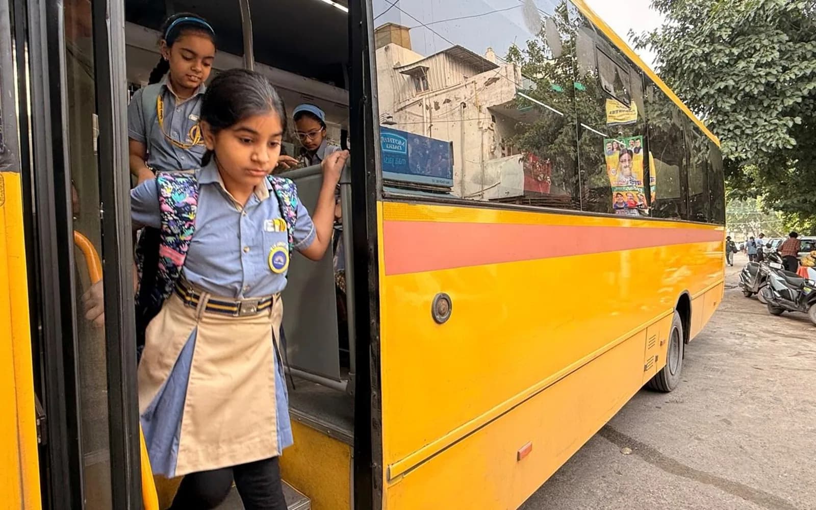 A student boarding a Salwan Junior School bus, welcomed by a staff member